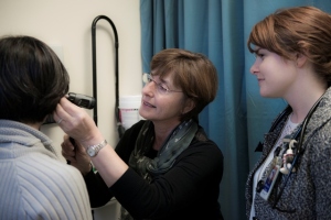 Dr. Silvia Guillemi, Director of the BC-CfE Clinical Education and Training Program, observes a patient at the IDC clinic as Dr. Kali Gartner, a R3 Family Practice resident, looks on.