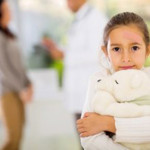 girl with band-aid on her face holding a teddy bear