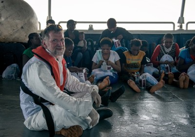Dr Simon Bryant sits close to a group of women that have just been brought on board the Phoenix.