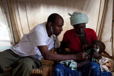 Jimale Mohamed, a MSF clinical officer, examines a young patient in the Out-patient Department of MSF's hospital in Doro refugee camp. Doro is one of three Upper Nile camps sheltering at least 113,000 refugees who have crossed the border from Blue Nile state to escape a counter-insurgency campaign conducted by heavily armed Sudanese government troops. Refugees arrive at the camp with harrowing stories of being bombed out of their homes in the north, or having their villages burned by northern soldiers. The camps into which they have poured are on a vast floodplain, leaving many tents flooded and refugees vulnerable to disease. Mortality rates are at emergency levels, and diarrhea and malarial cases are rising. Doctors have already laid preparations for a cholera outbreak.