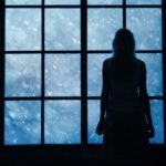 Lonely women looking at snowfall through big glass window