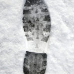 Close up of a footprint in the snow.