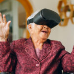 Asian old senior wearing vr headset feeling excited with metaverse. Retirement and senior lifestyle at home